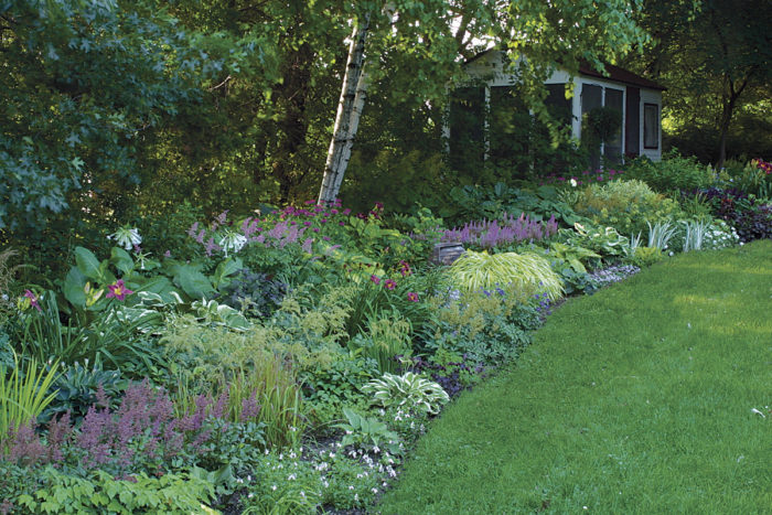 screen house nestled into a shady border