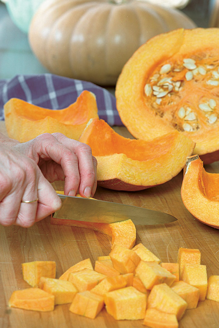 close up of hands cutting pumpkin