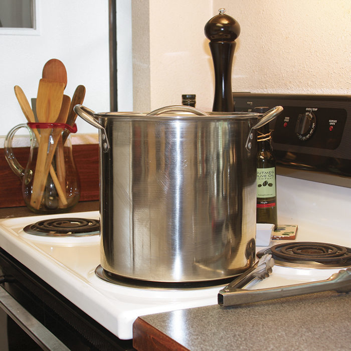 a tall stock pot on an electric stove with coil burners