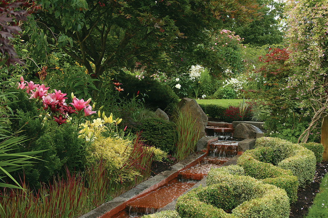 an angular waterfall feature flows alongside classic cottage-garden plants