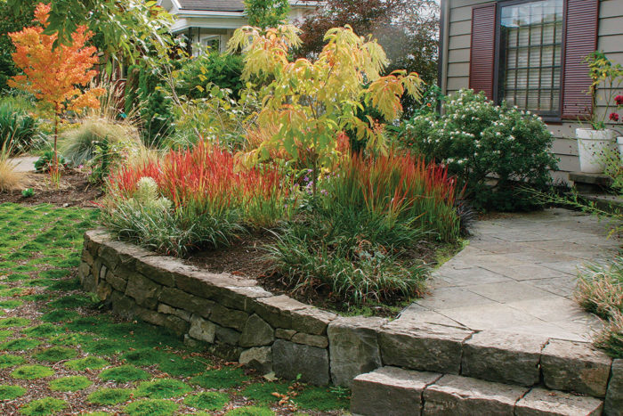 the stone wall also serves to create a raised bed and a place to sit.