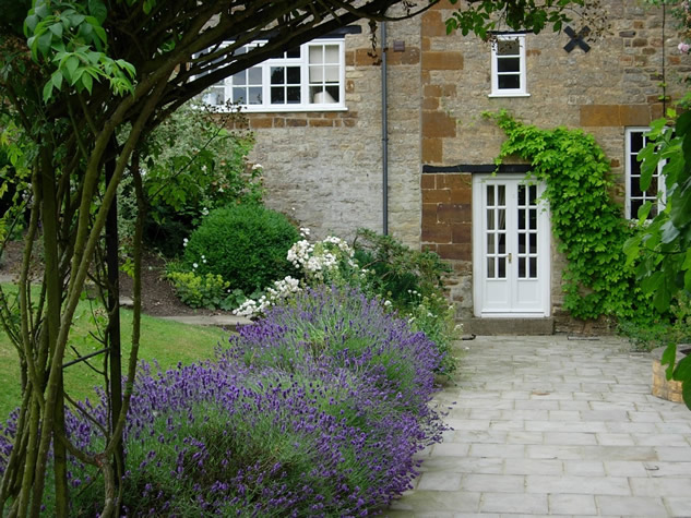 flowers planted next to a stone path walkway leading to a house  Photo/Illustration: James Alexander-Sinclair