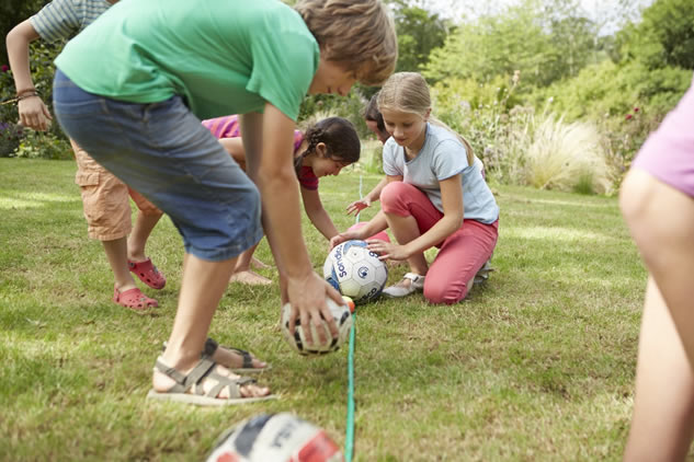 people holding soccer balls and filling them up with water