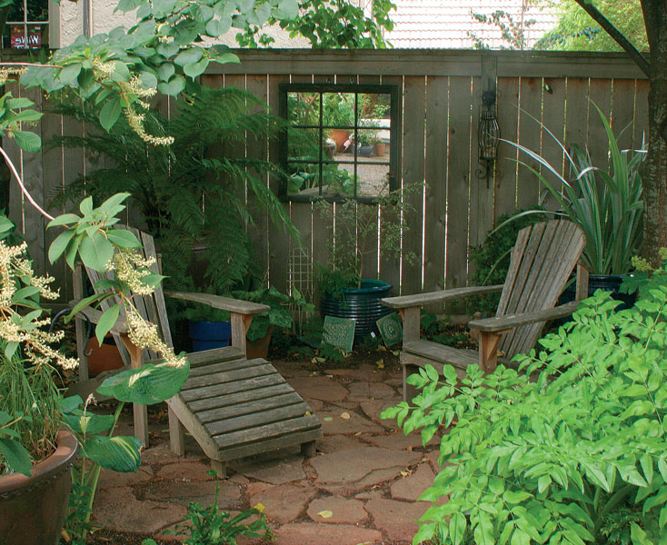 An artfully decorated fence forms the backdrop for the author's cozy outdoor seating area.