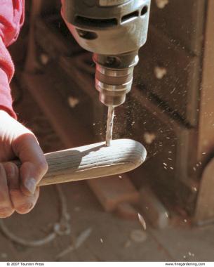 Drill holes in tool handles so they can be easily hung from nails affixed to the walls of a garage or storage shed.