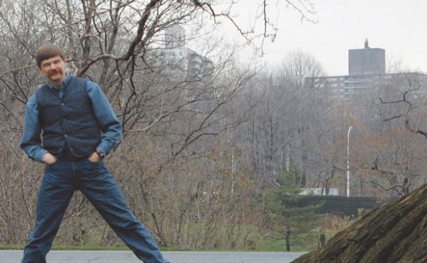 man standing tilted in front of a tree