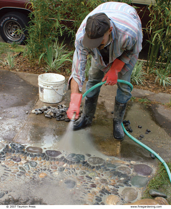 Author spraying mosaic with hose to clean off any displaced mortar.