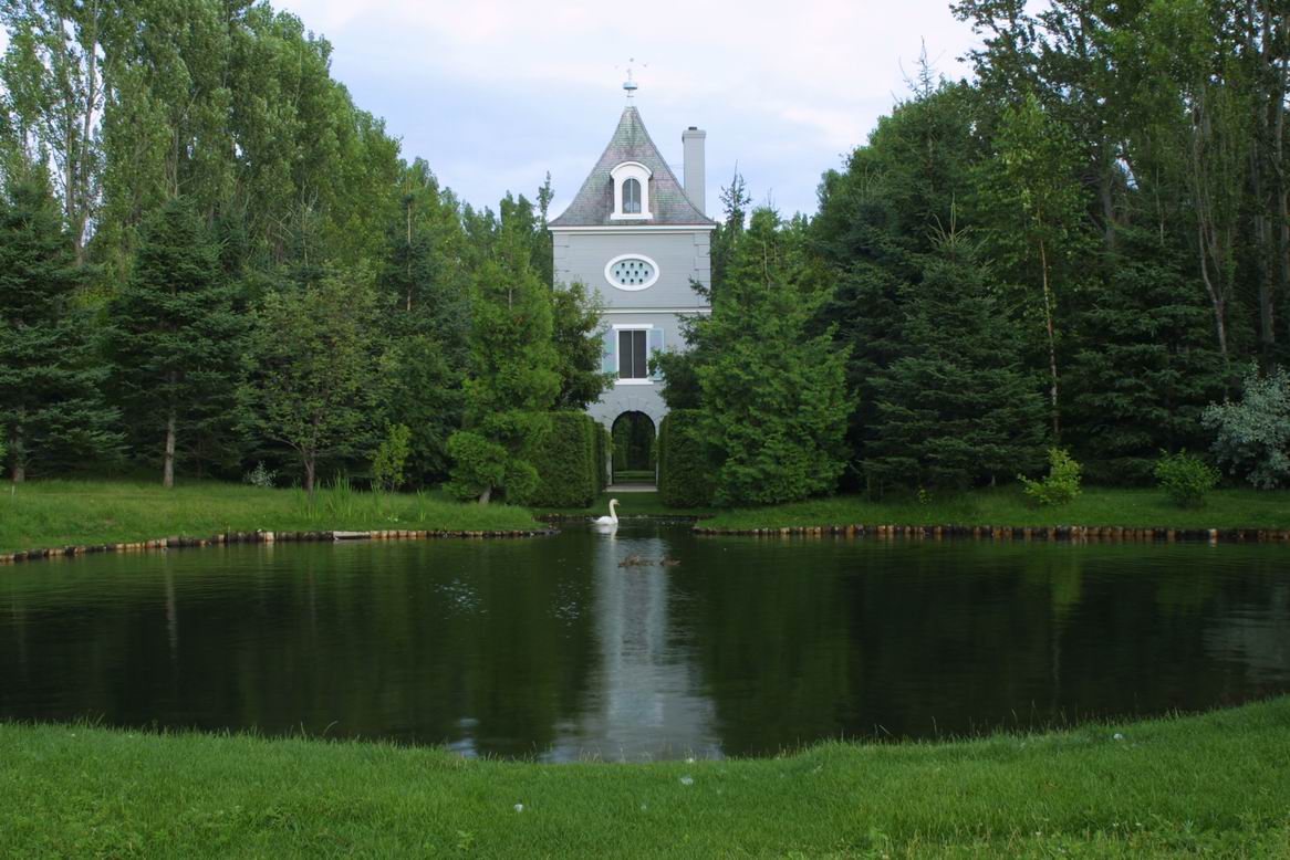 The pigeonnier at Les Quatre Vents with a pond and a swan in front