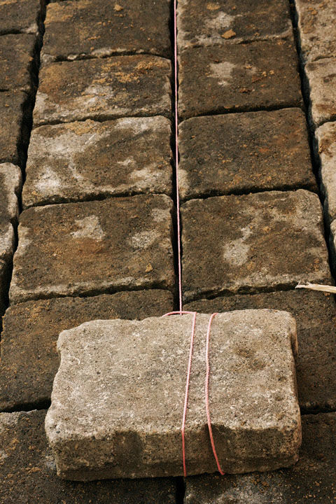 square line set up as a guide between the pavers