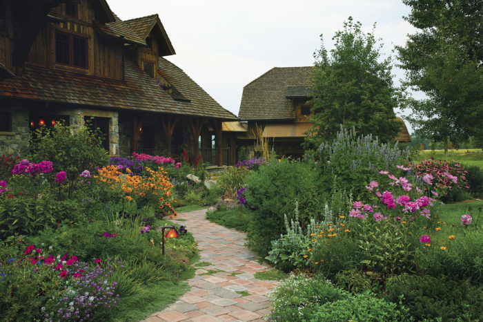 View of the house with a pathway with colorful flowers on either side