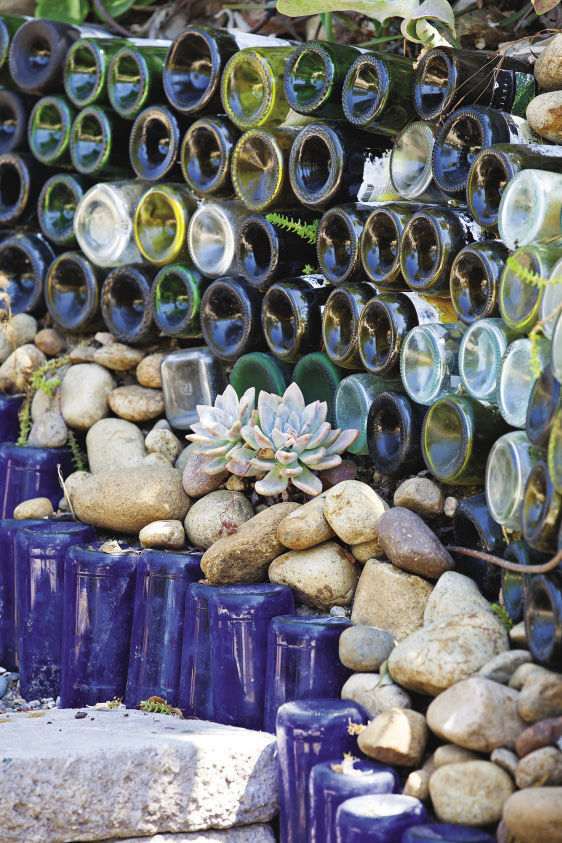 colorful bottles and stones in the garden as an informal wall