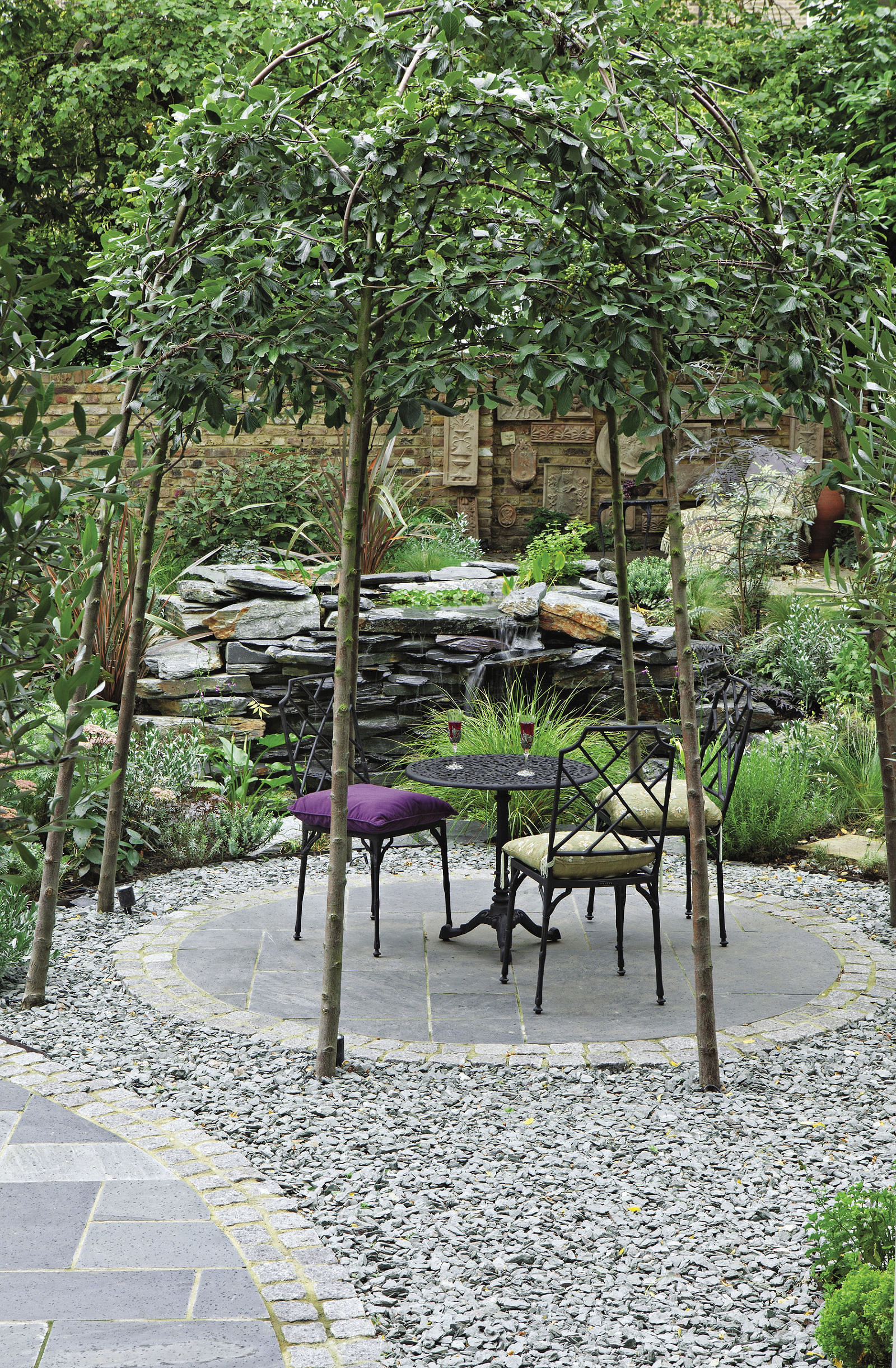 small table and chairs under trees forming a small natural roof