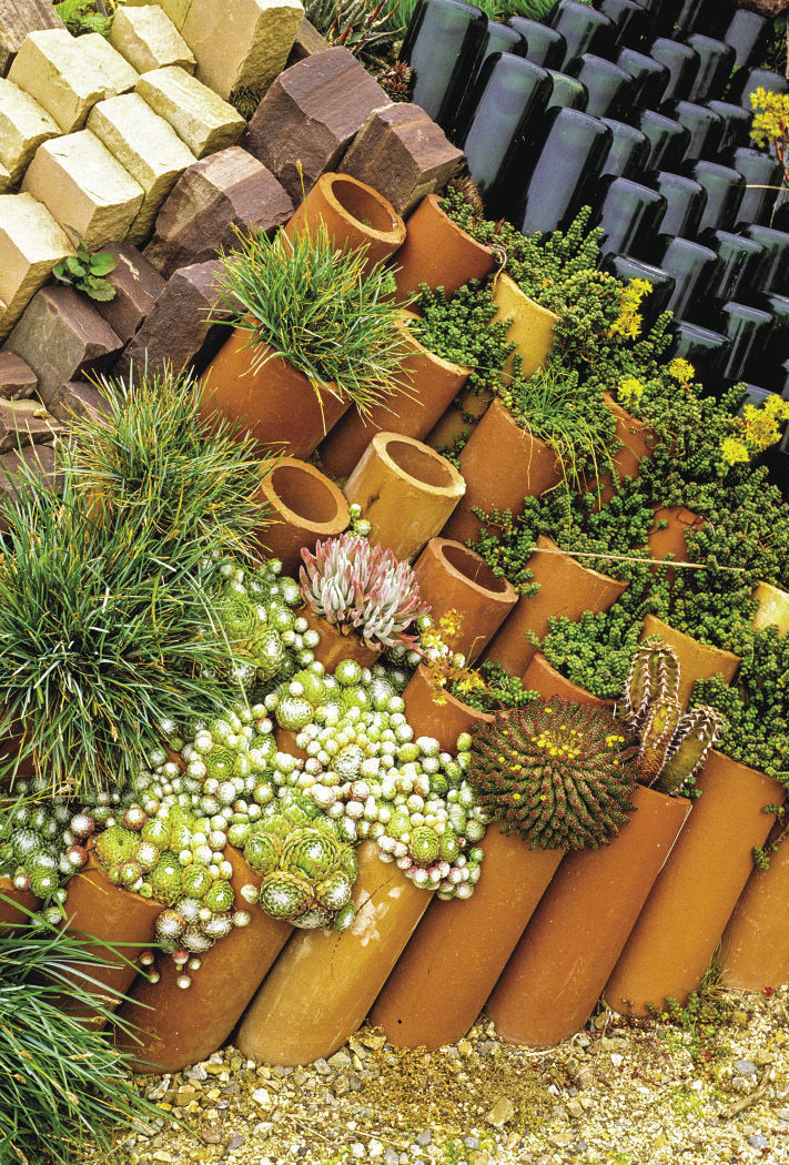 terra-cotta pipes arranged on an angle with succulents in them