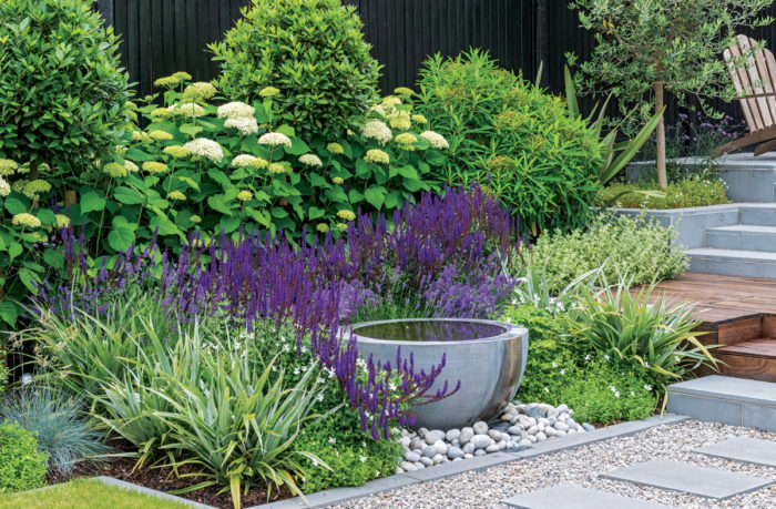 View of modern flower bed with water bowl.