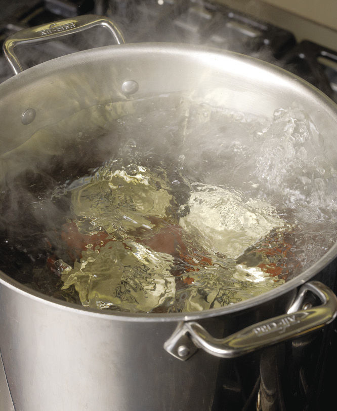 jars boiling in a large water-filled stock pot on the stove