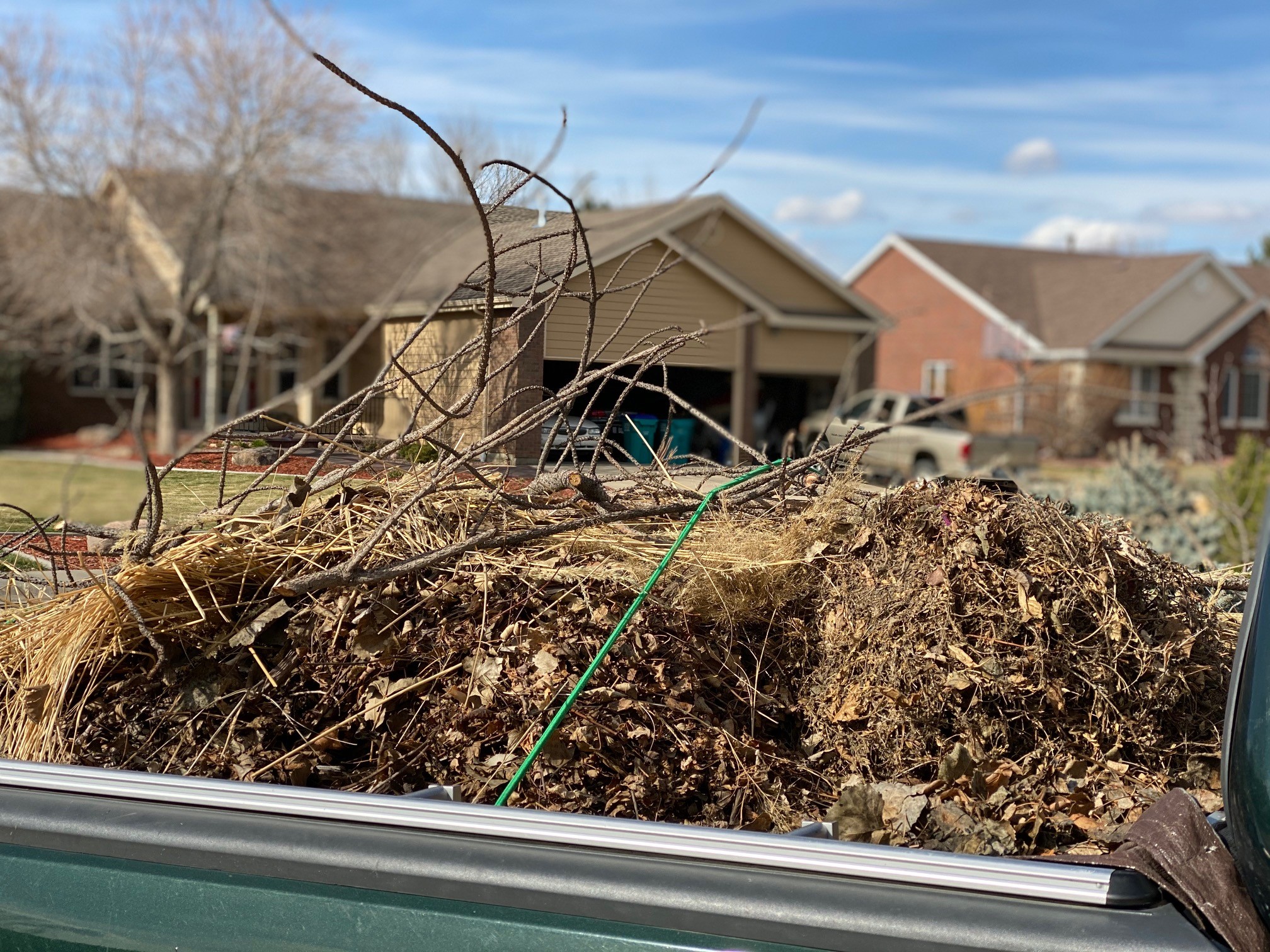 compost bin with brown material and stick 