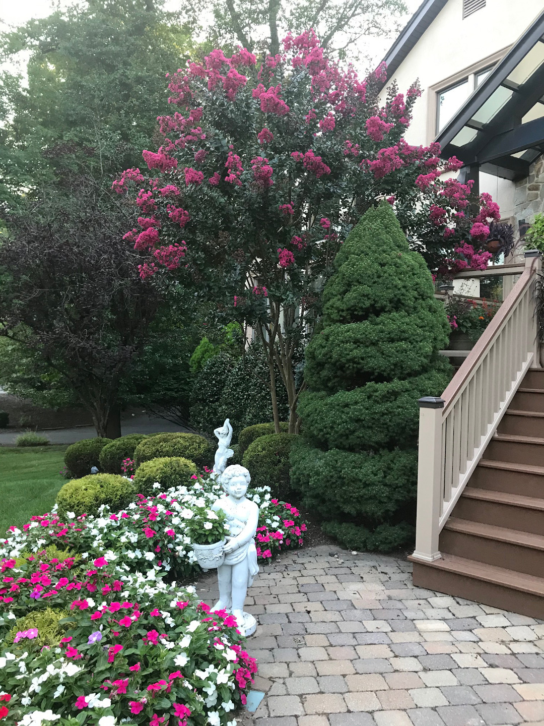 Flowering plants around the front steps of a house.