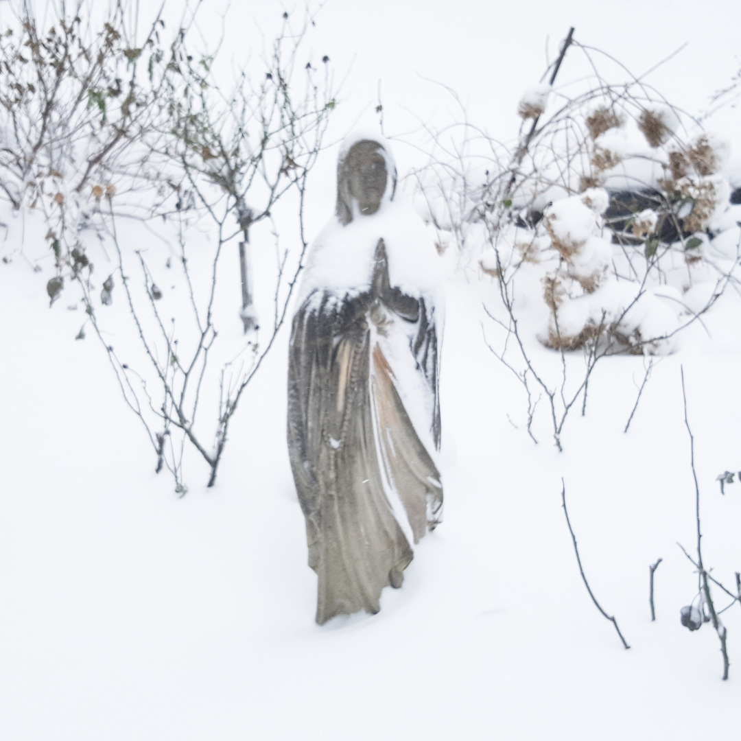 A statue in a snowy garden