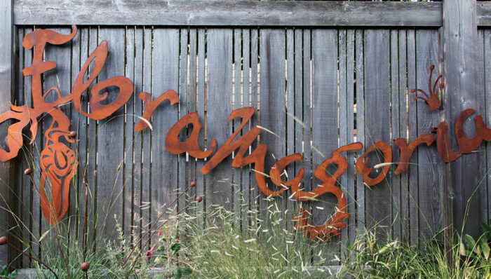 metal sign with name of garden on fence