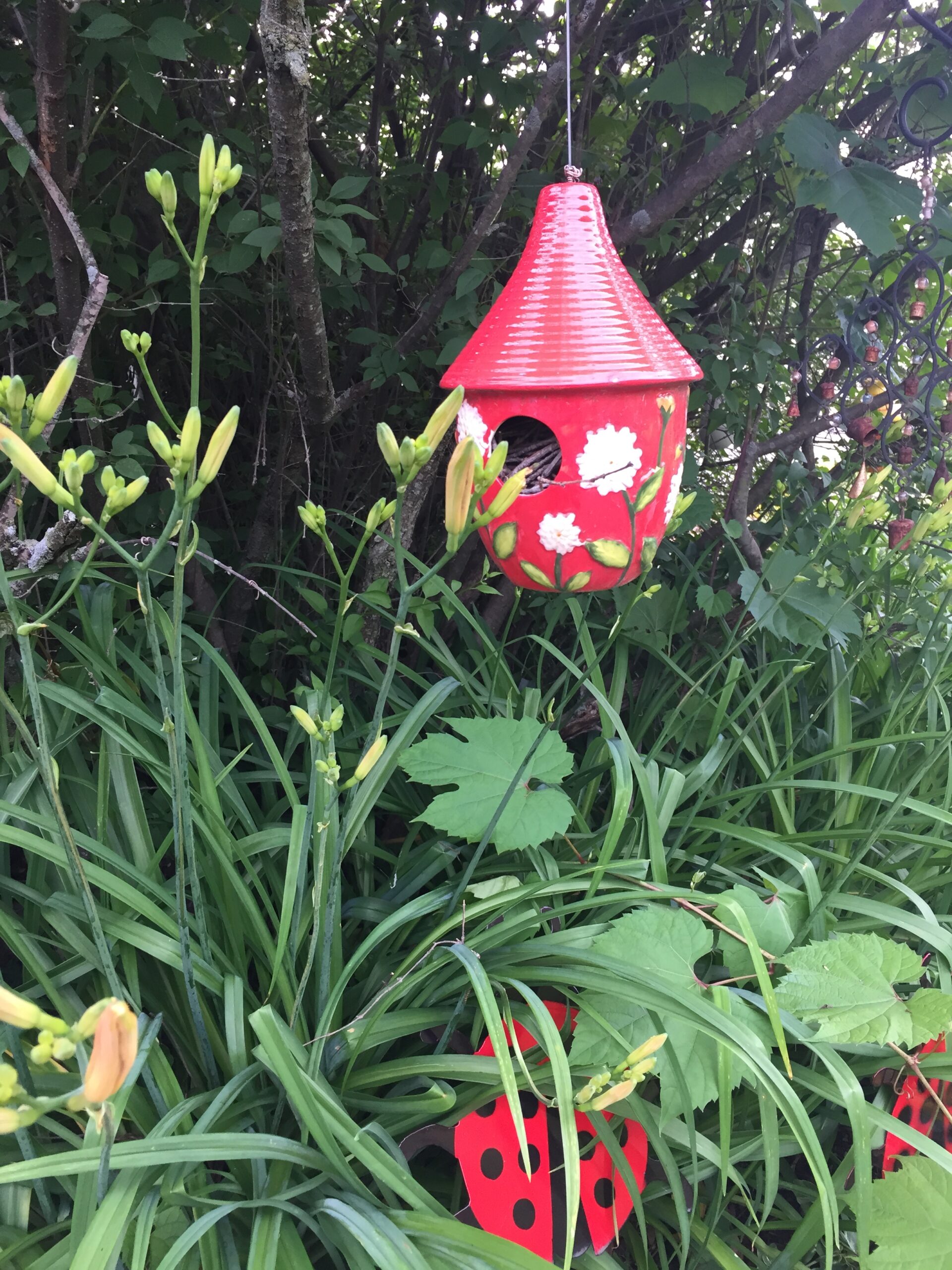 birdhouse above daylilies