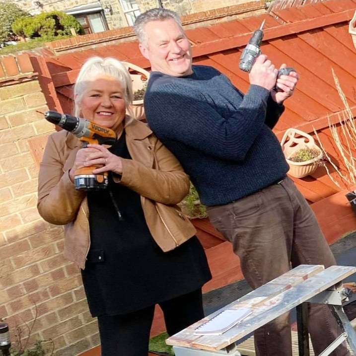 A couple holding electric drills