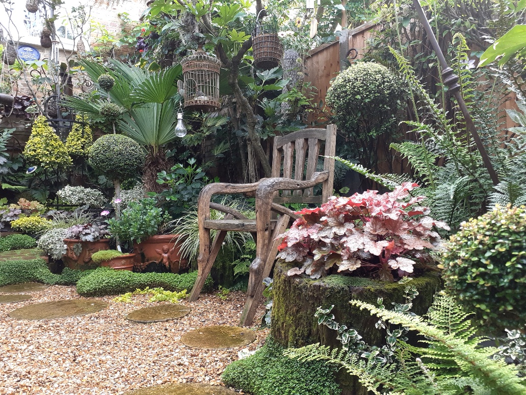 wooden garden chair surrounded by lush plants