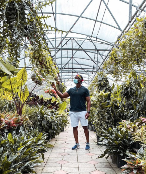 man at a nursery checking out plants