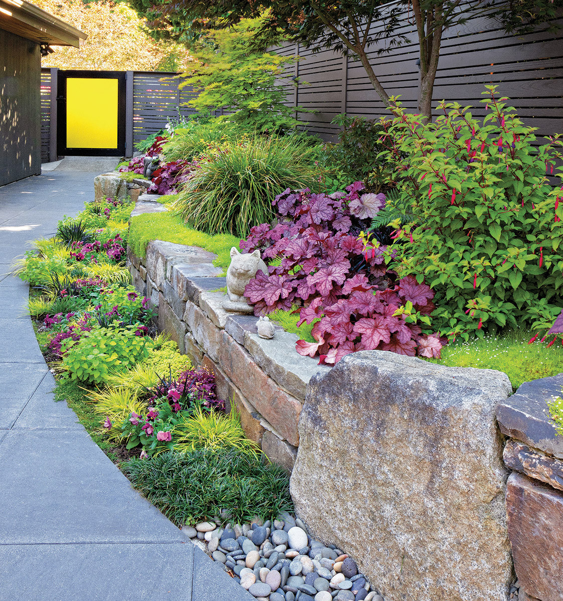 Chartreuse can unite a planting by being the main theme of the area. Picking up on the yellow of the door, the chartreuse plants here create a vibrancy to the bed that the area needs, given the dark and gray hardscape. Using the yellow of the door throughout the bed would have been garish, requiring sunglasses of anyone attempting to view it. The numerous pops of purple provide a counterpoint to the chartreuse and a connection to the house and the fence.