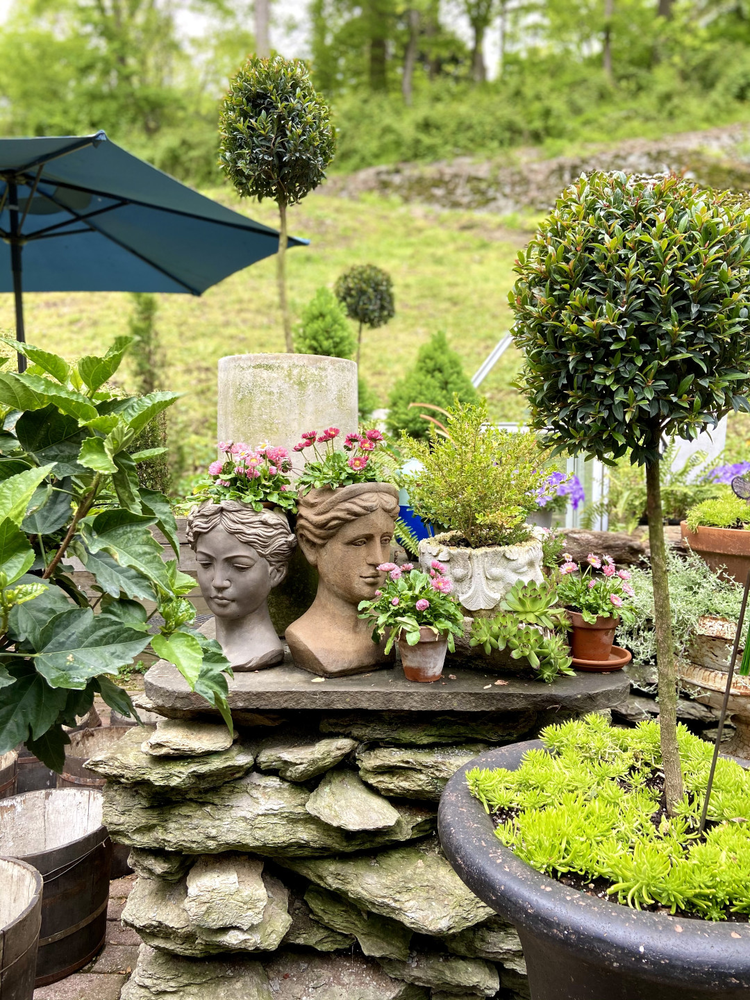 Planter in the shape of faces filled with flowers