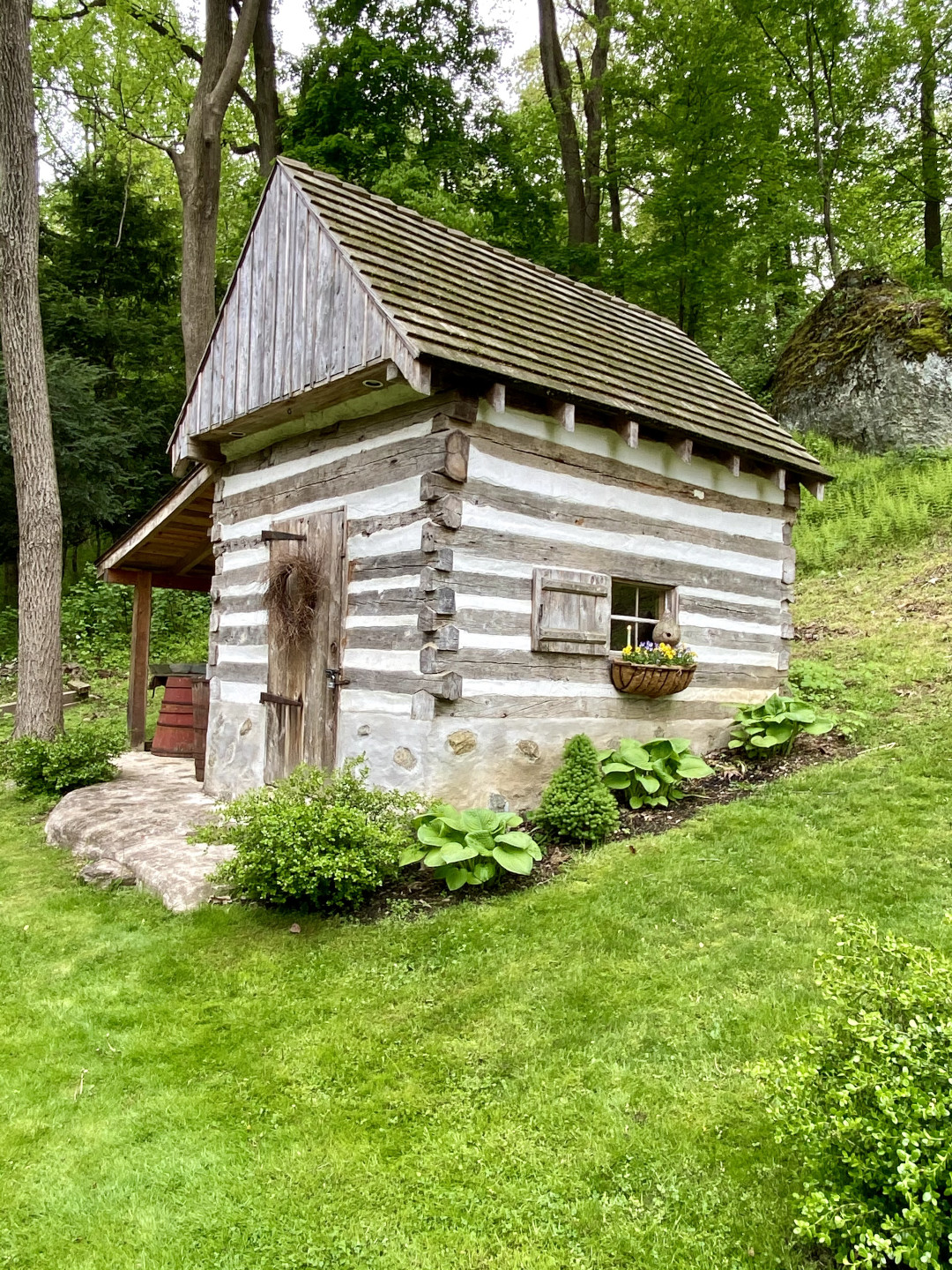 A small log cabin on a grassy hillside