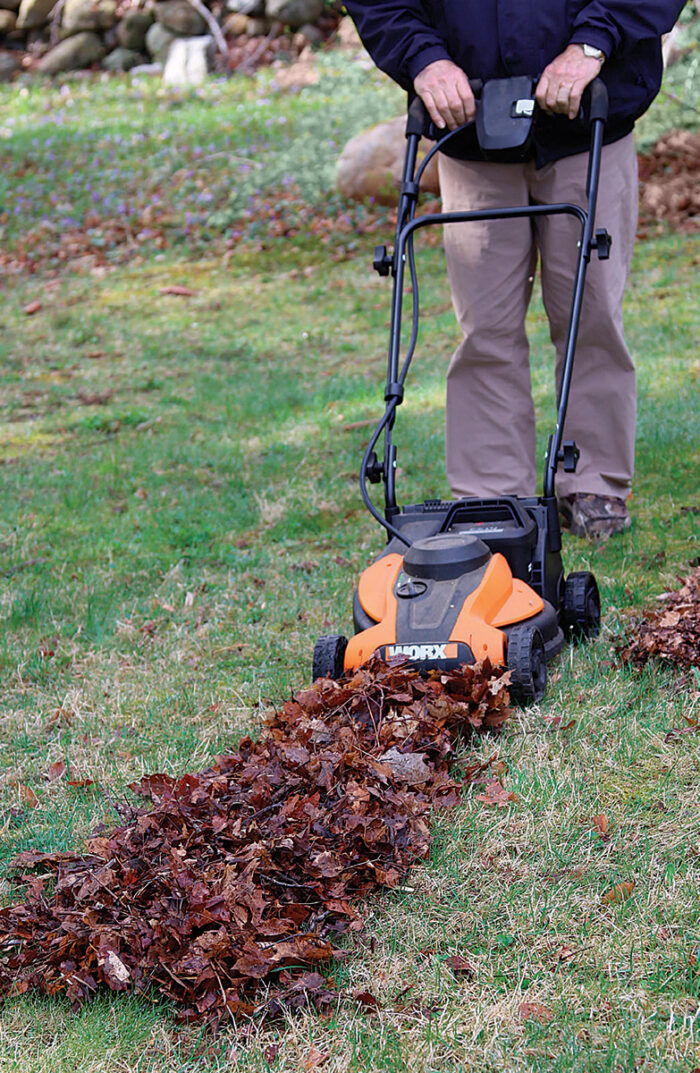 Man mulching leaves with a lawn mower.