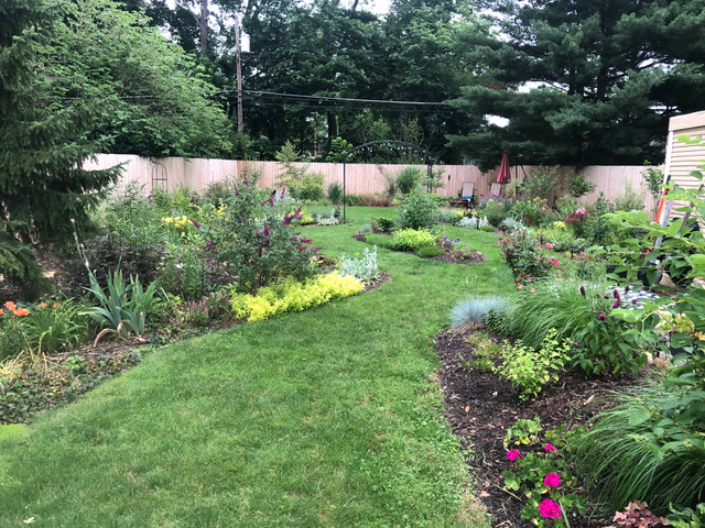 backyard with lots of garden beds and tan fence