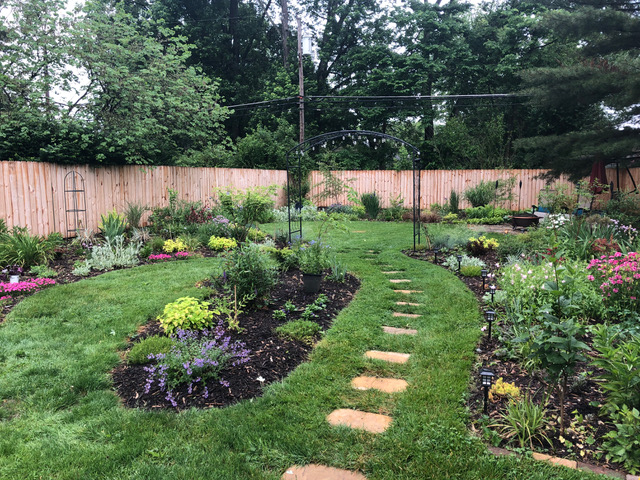 stepping stones buried in grass through garden beds