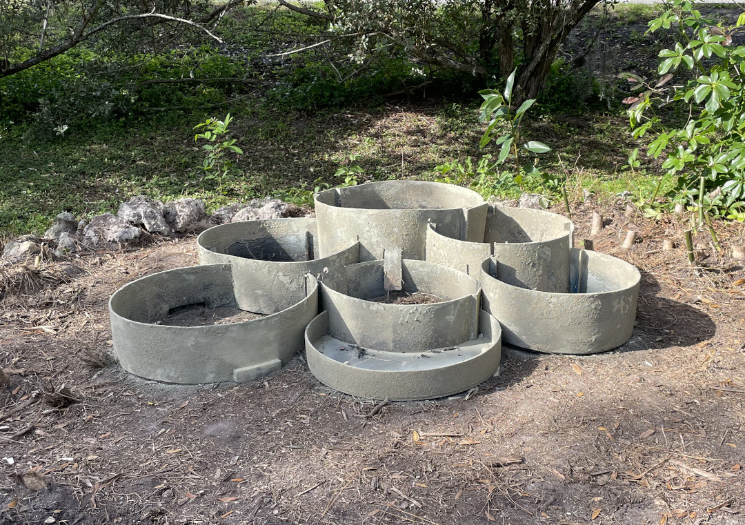 Rings set in the ground covered with sand and painted to resemble stone