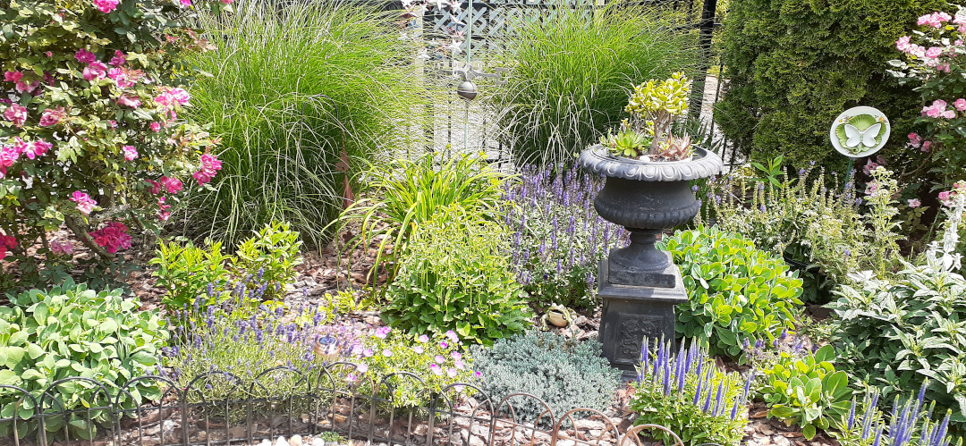 garden bed with a tall urn in the center of it