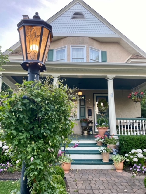 front of home with light post and plants