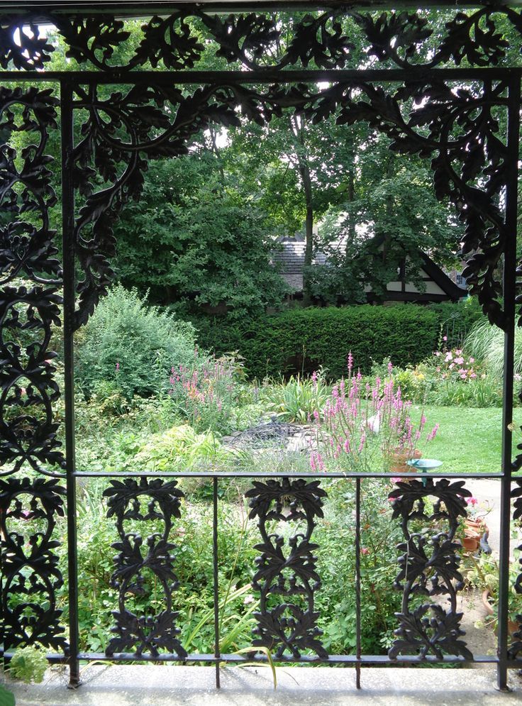 garden view from a patio with ornate iron railing