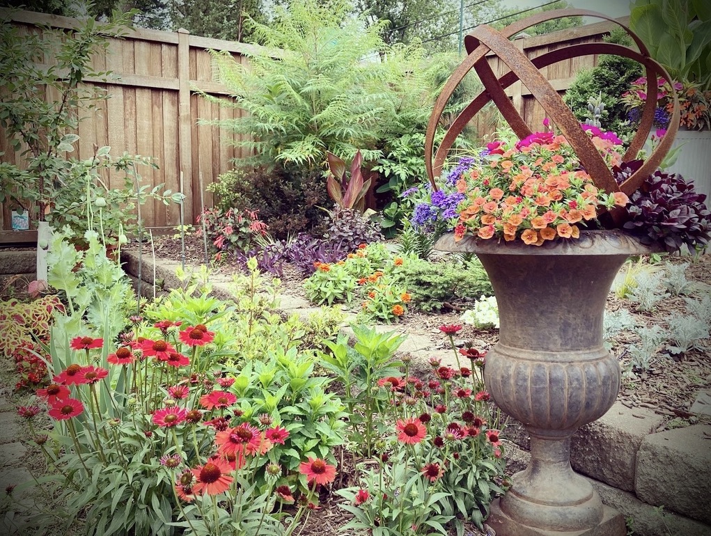 rusty garden art in a bed full of flowers