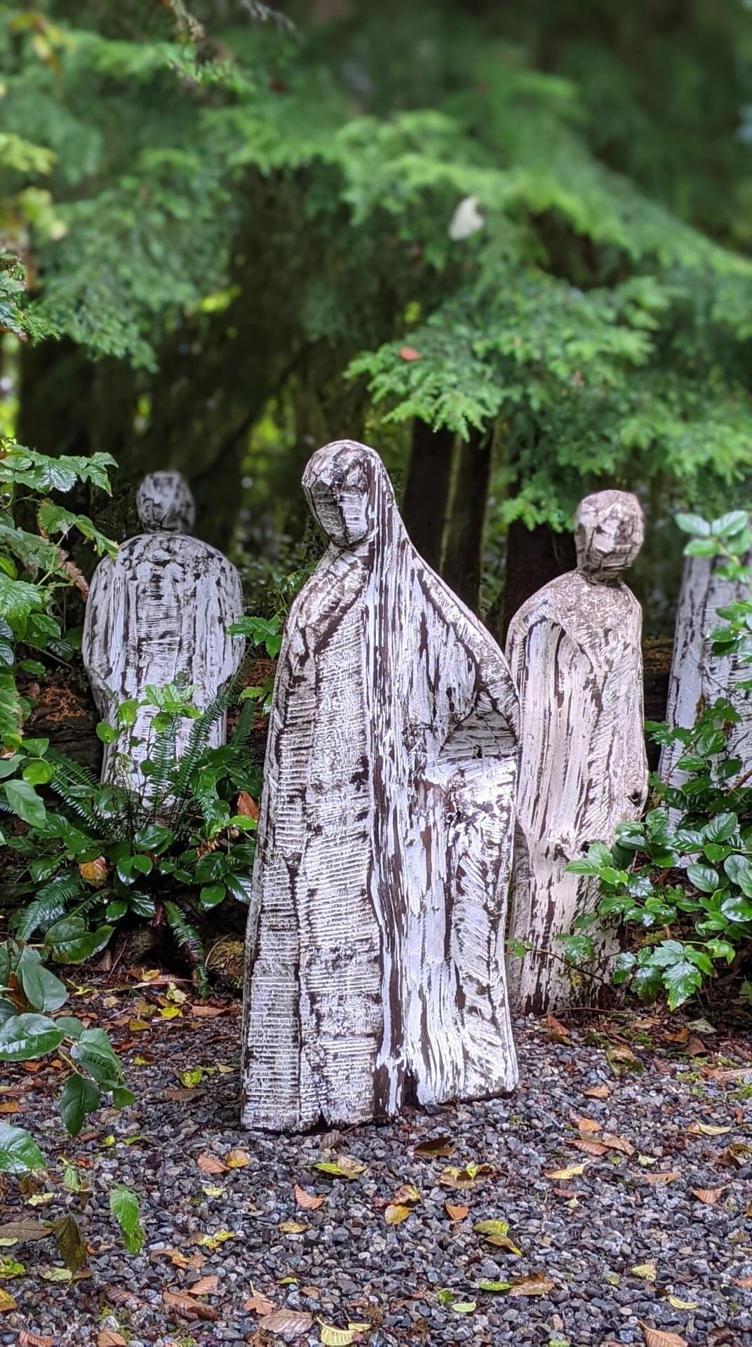 wooden figures in the lush green of the temperate rainforest