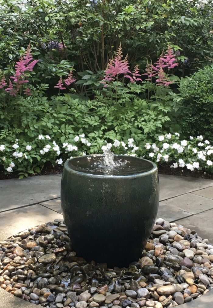 water fountain with flowers in the background