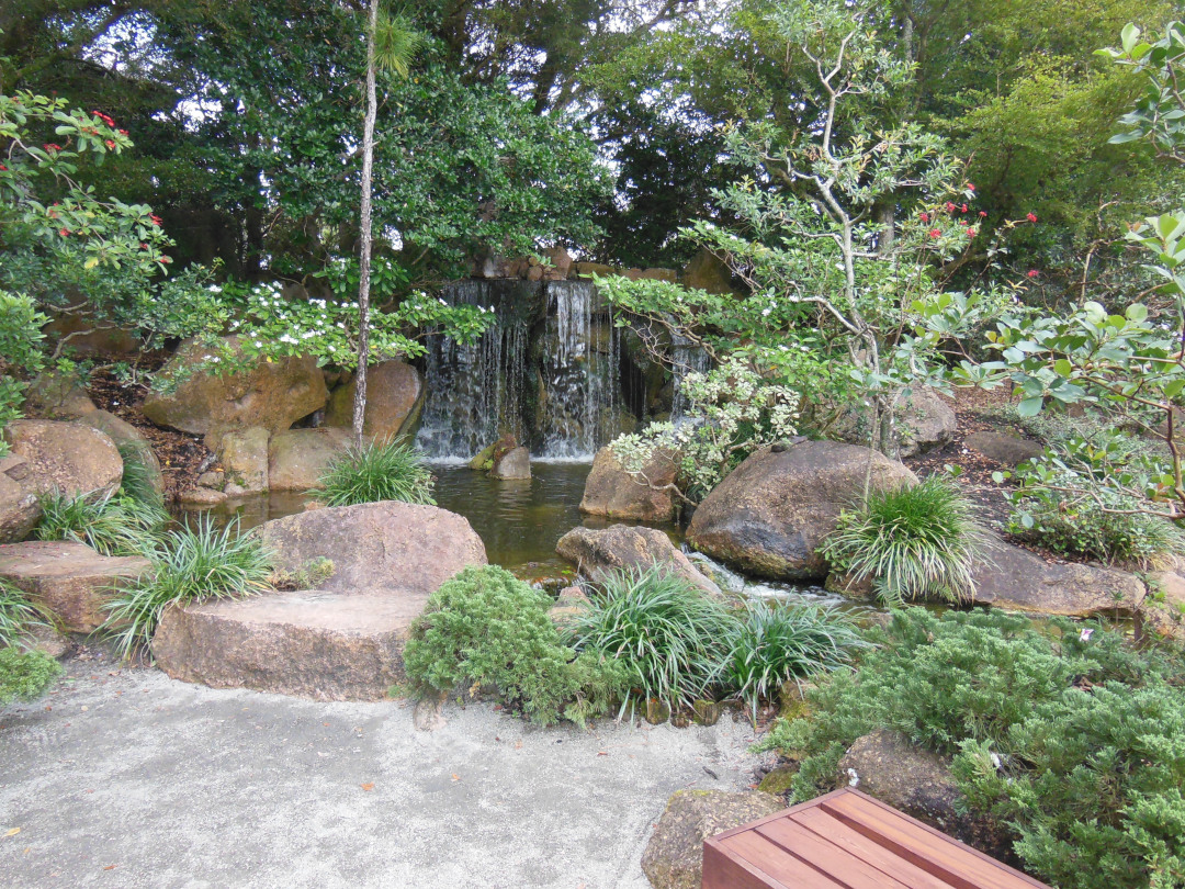 waterfall and lake surrounded by greenery