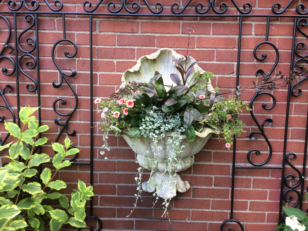 small wall-mounted planted with flowers and foliage plants