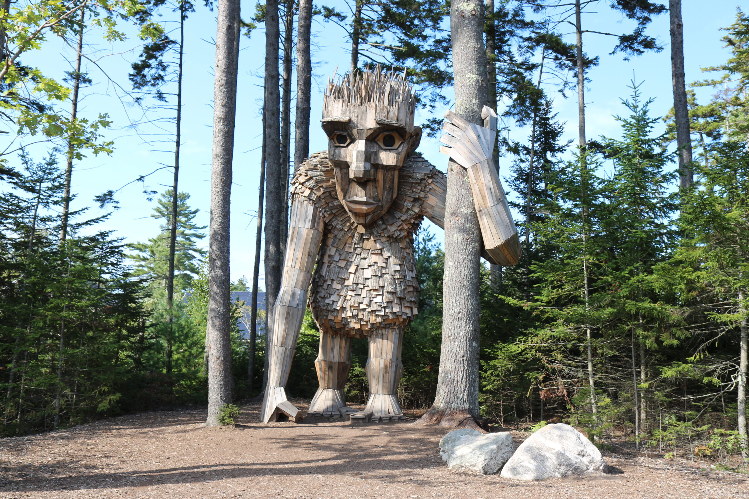 large wood sculpture of a man in the woods