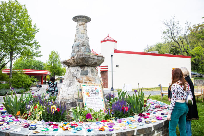 old stone fountain with plants planted inside and crocheted around