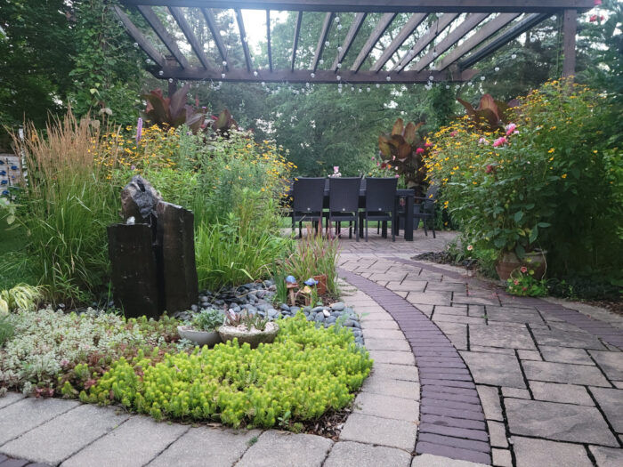 garden beds around stone path leading to patio