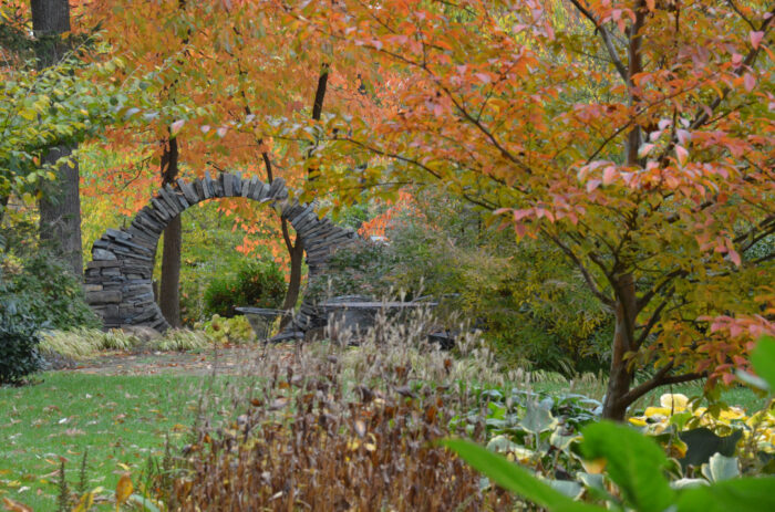 fall garden with fall foliage and moon gate in the distance