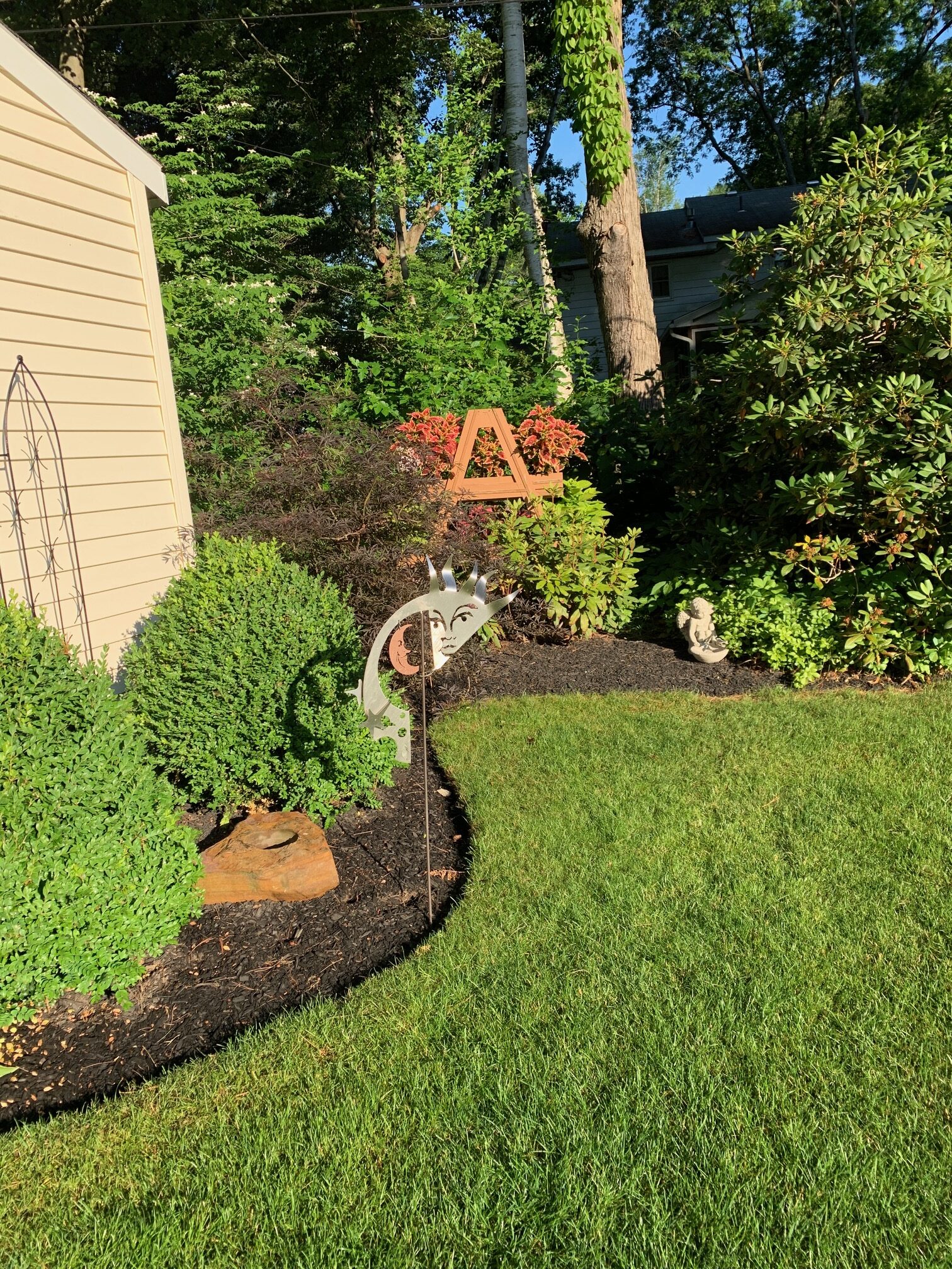 curved garden bed with several shrubs