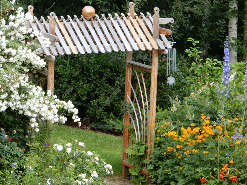 garden arbor surrounded by flowers in summer