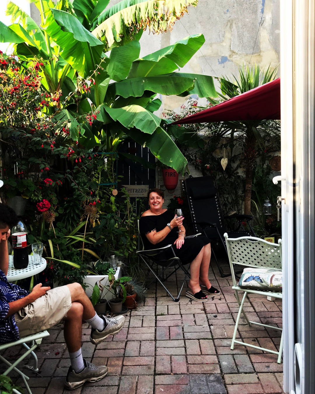 La gente disfruta de bebidas a la sombra del jardín del patio.