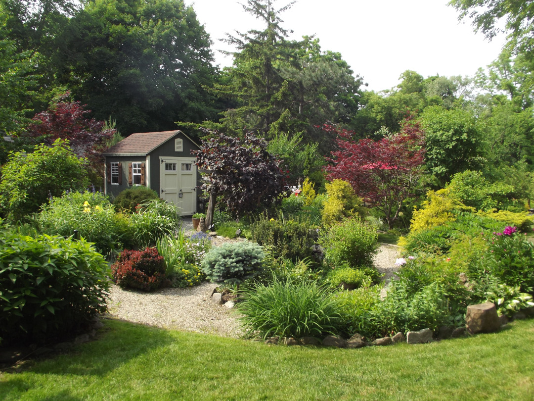 garden shed surrounded by gravel path and garden beds